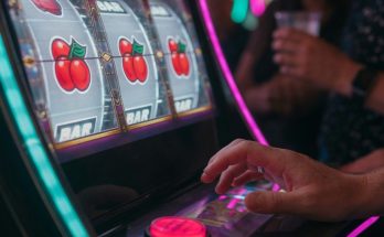 Photo depicting gambling psychology: near-miss slot, hesitant hand, blurred onlookers applying pressure.